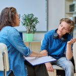 Teen Speaking with a Mental Health Counsellor in a school setting.