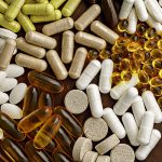 multivitamin dietary supplements on a clay plate. dietary supplements top view. mental wellbeing and personal health concept.