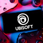 Kazan, Russia - Apr 15, 2022: Ubisoft is French video game company. Smartphone with Ubisoft logo on screen surrounded by gamepads.