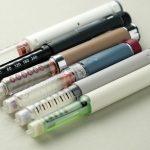 Close-up of multiple injection pens with needles. Concept of semaglutide, GLP-1 drugs, insulin therapy, obesity treatment, diabetes care, pharmaceutical market and weight loss medication.
